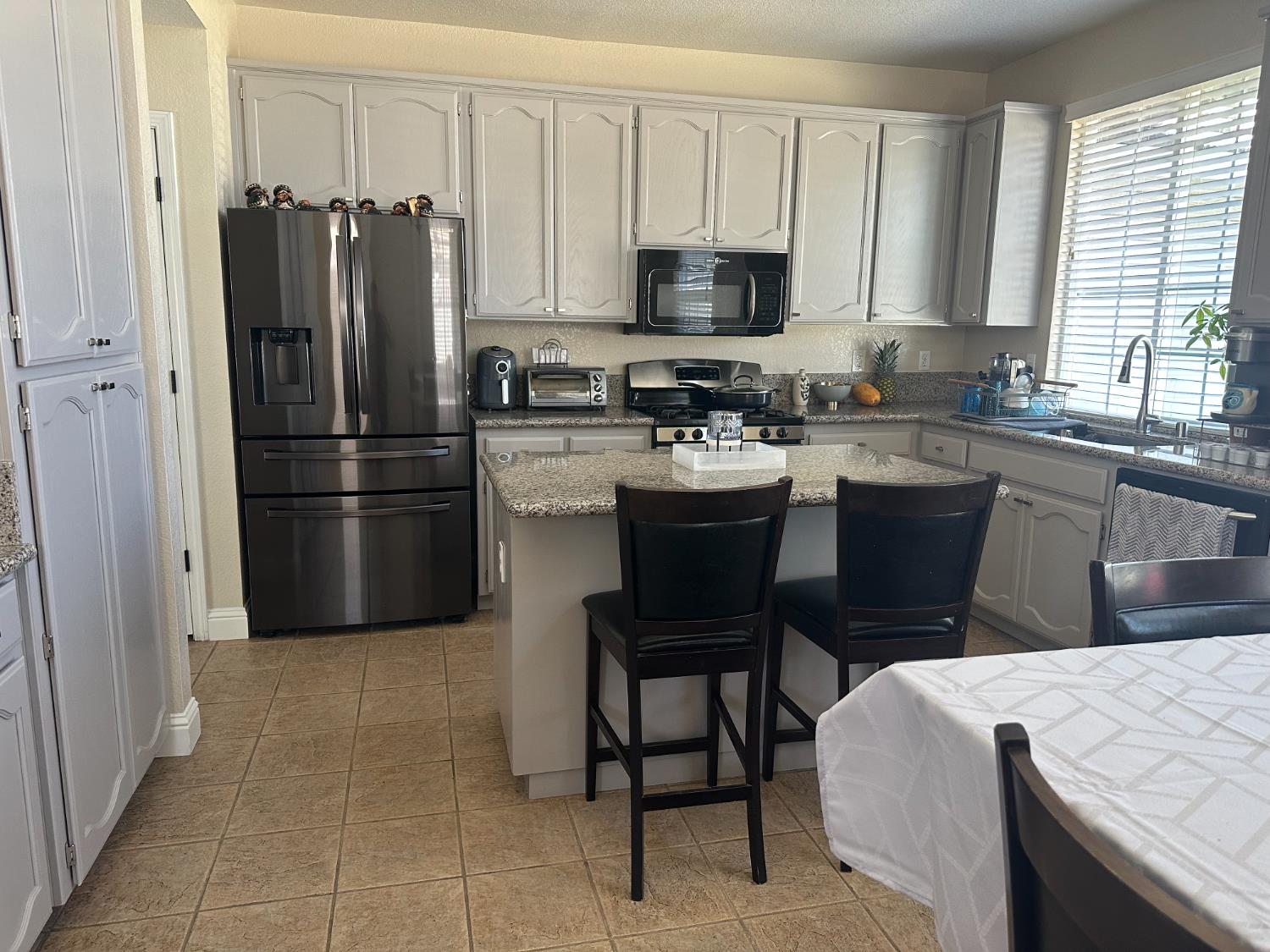 628 Mission Ridge Drive Manteca, CA 95337 - Photo 12 of 27 a kitchen with a refrigerator and a stove top oven