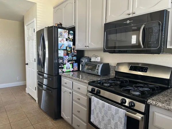 a kitchen with stainless steel appliances granite countertop a refrigerator stove and microwave