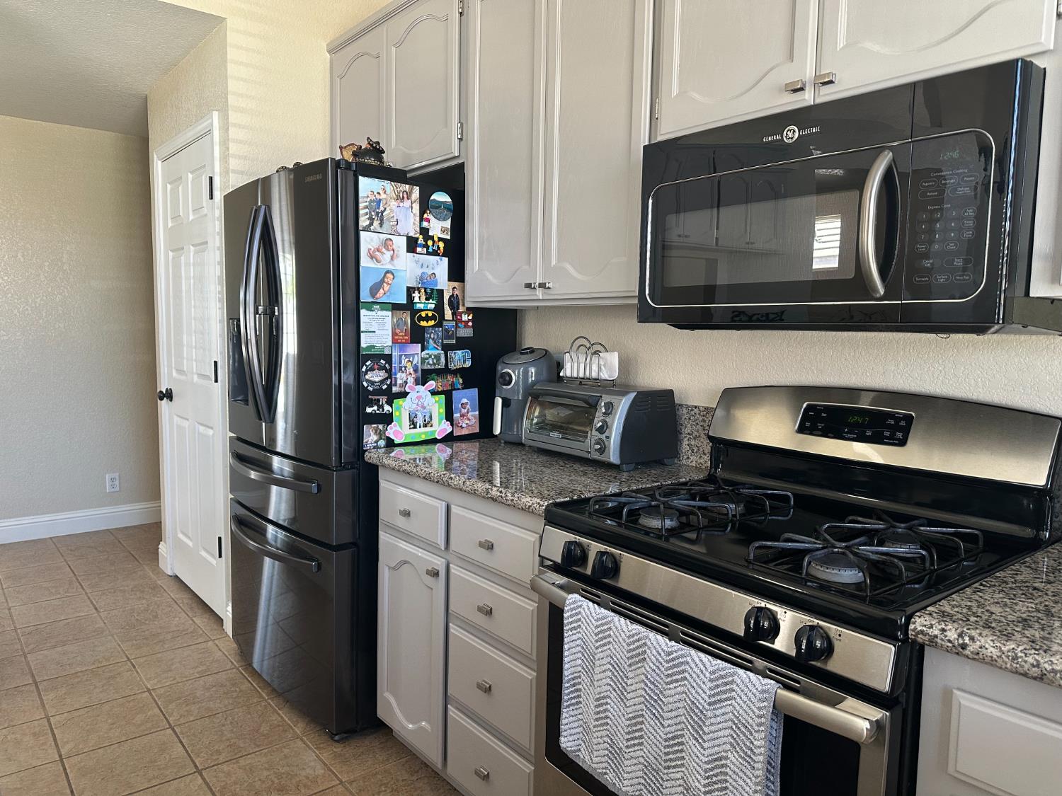 628 Mission Ridge Drive Manteca, CA 95337 - Photo 14 of 27 a kitchen with stainless steel appliances granite countertop a refrigerator stove and microwave