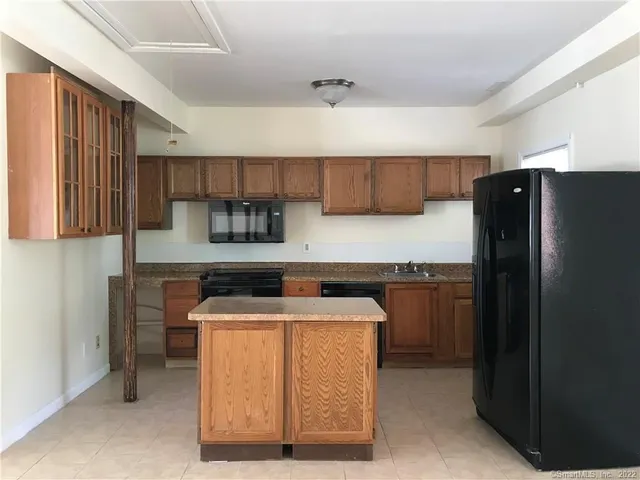 a kitchen with stainless steel appliances granite countertop a refrigerator a stove a sink and a microwave