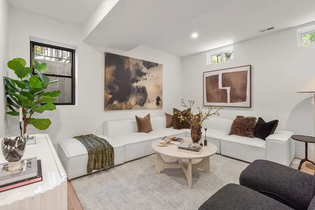 a living room with furniture potted plant and window