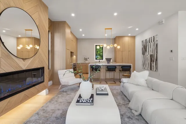 a living room with furniture a fireplace and a large mirror