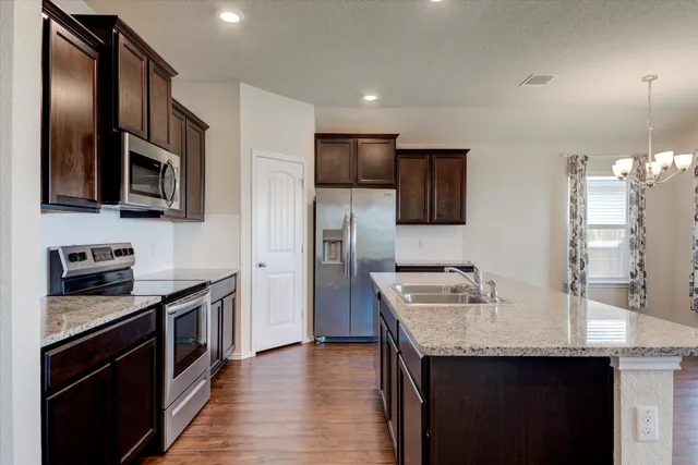 a kitchen with stainless steel appliances granite countertop a sink stove and refrigerator