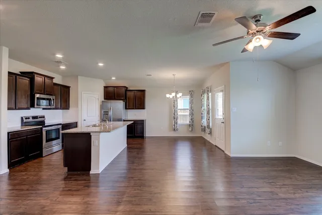 a view of kitchen with microwave stove top oven and cabinets