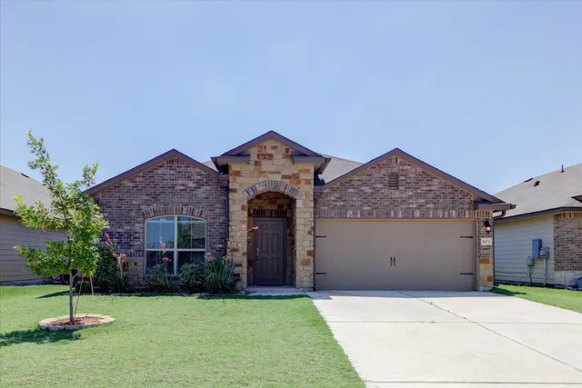 a front view of a house with a yard and a garage