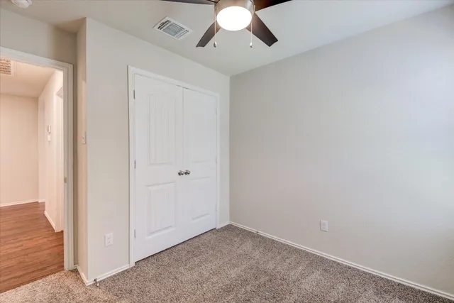 an empty room with chandelier fan