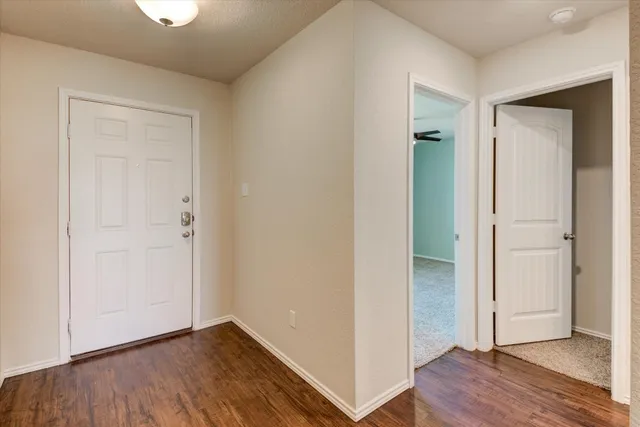 an empty room with wooden floor & closet area