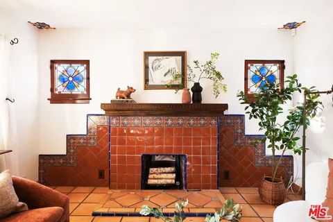 a living room with furniture a fireplace and a potted plant