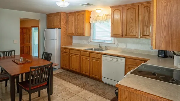 a kitchen with stainless steel appliances granite countertop a sink refrigerator and cabinets