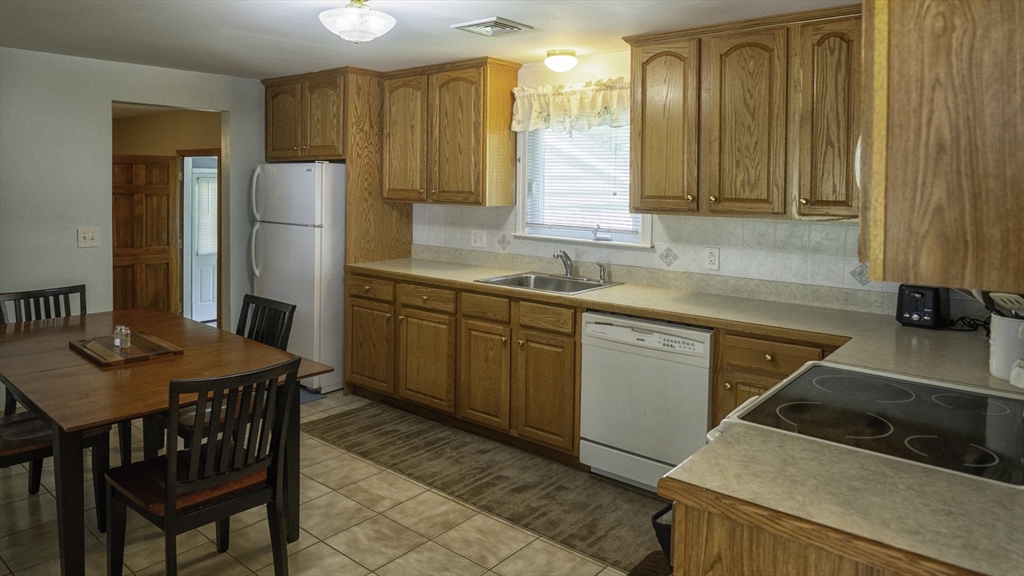 118 Walton Avenue Barnstable, MA 02601 - Photo 4 of 16 a kitchen with stainless steel appliances granite countertop a sink refrigerator and cabinets