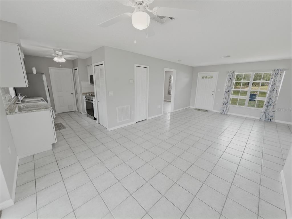 2202 Godfrey Avenue Spring Hill, FL 34609 - Photo 10 of 36 an empty room with a fireplace and windows