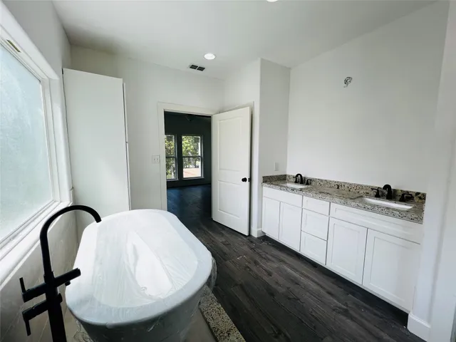 a bathroom with a granite countertop sink and cabinets