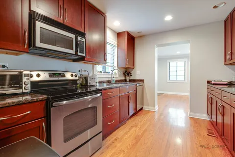 a kitchen with stainless steel appliances granite countertop wooden cabinets stove top oven and sink