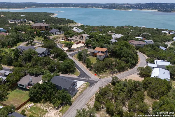 an aerial view of residential houses with outdoor space and ocean view