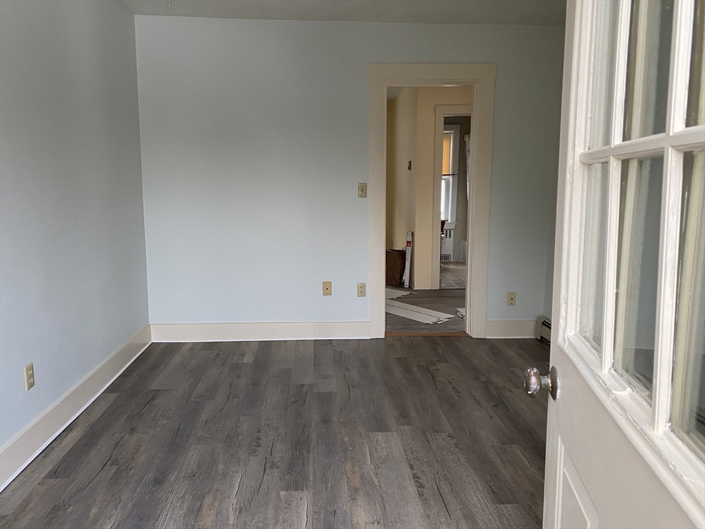 21 North Warren Street, Unit 2 Woburn, MA 01801 - Photo 8 of 12 an empty room with wooden floor and windows