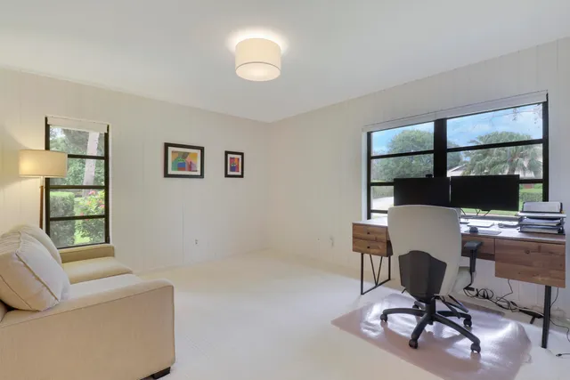 a view of a workspace with furniture and a window
