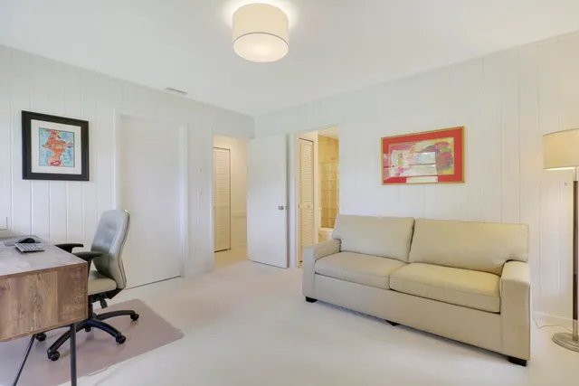 a living room with furniture and a air conditioner vent