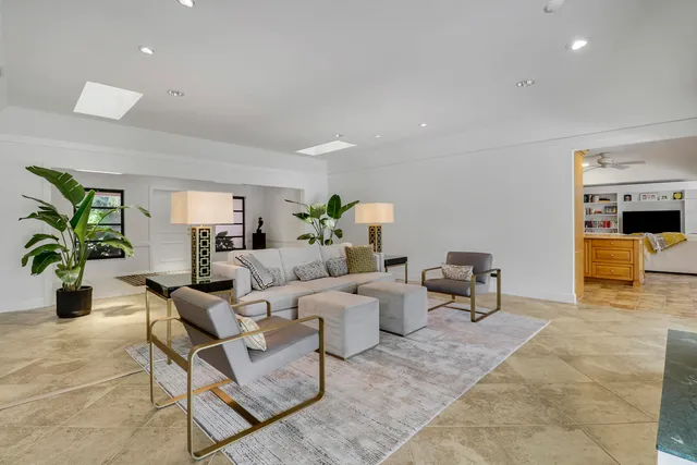 a living room with furniture and a view of kitchen