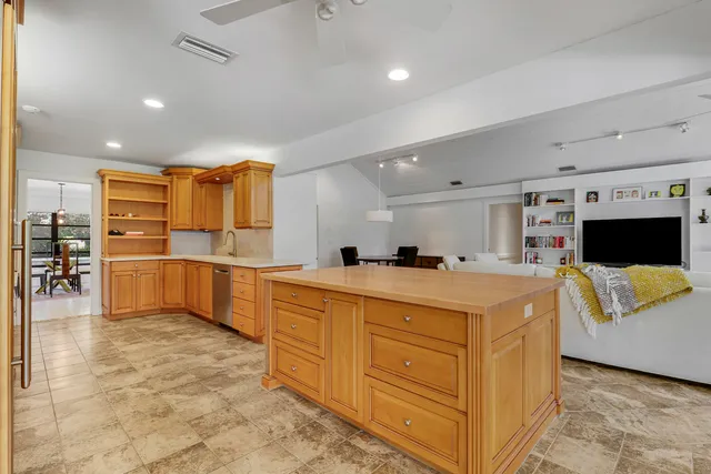 a large white kitchen with kitchen island a sink a stove and a refrigerator