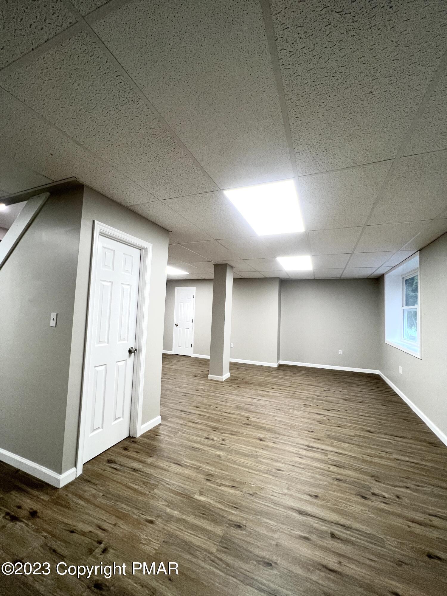 179 Gold Finch Road Bushkill, PA 18324 - Photo 12 of 15 an empty room with wooden floor and windows