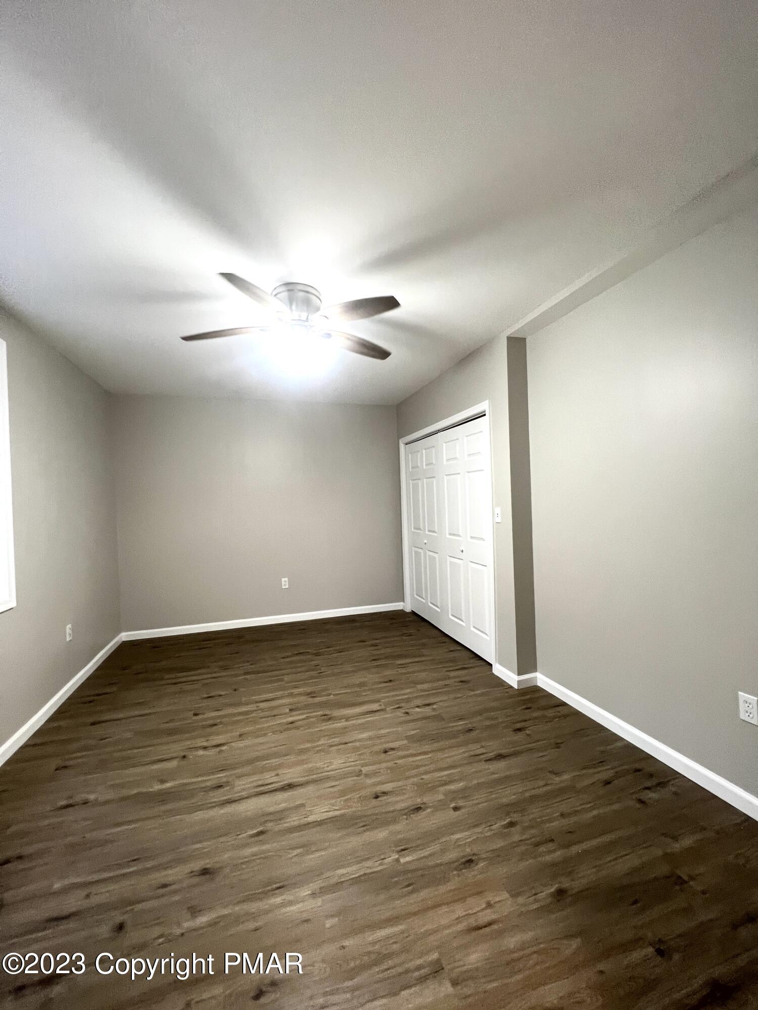 179 Gold Finch Road Bushkill, PA 18324 - Photo 13 of 15 a view of an empty room with wooden floor and fan