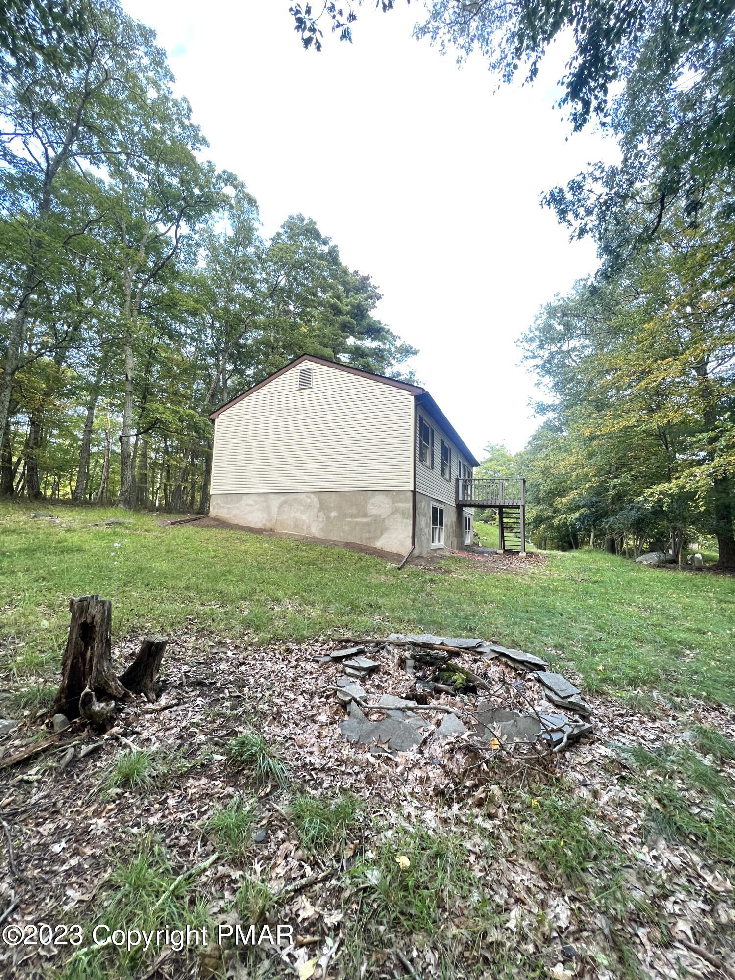 179 Gold Finch Road Bushkill, PA 18324 - Photo 14 of 15 a backyard of a house with plants and large trees