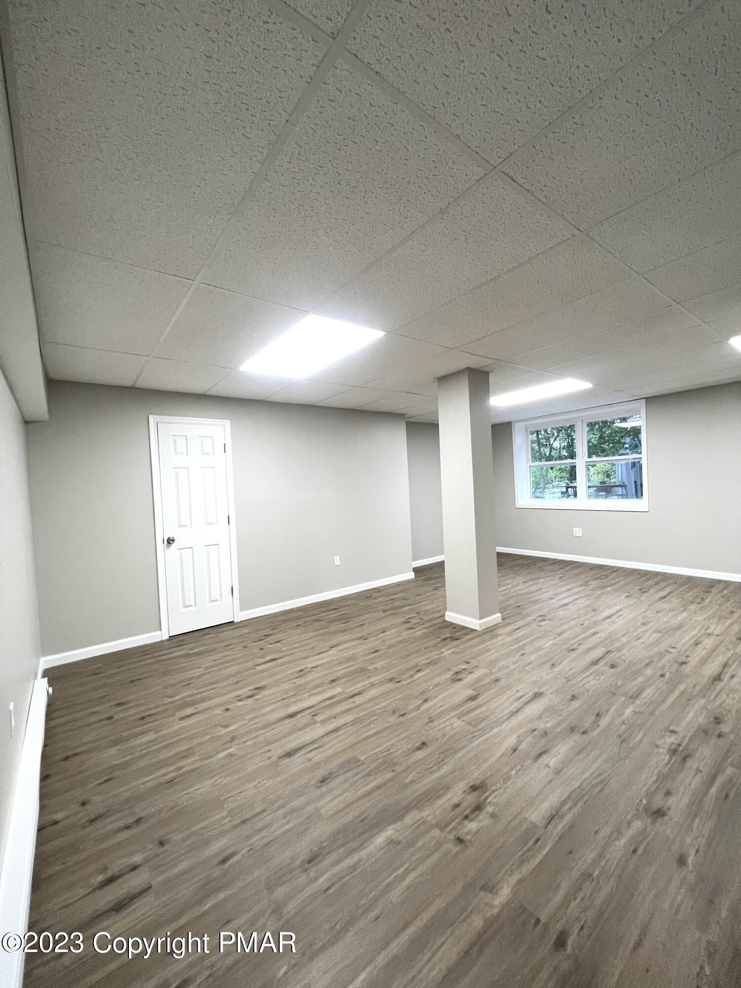 179 Gold Finch Road Bushkill, PA 18324 - Photo 10 of 15 an empty room with wooden floor and windows