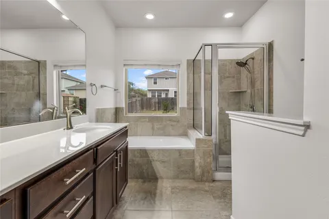 a bathroom with a granite countertop sink a bathtub and a shower