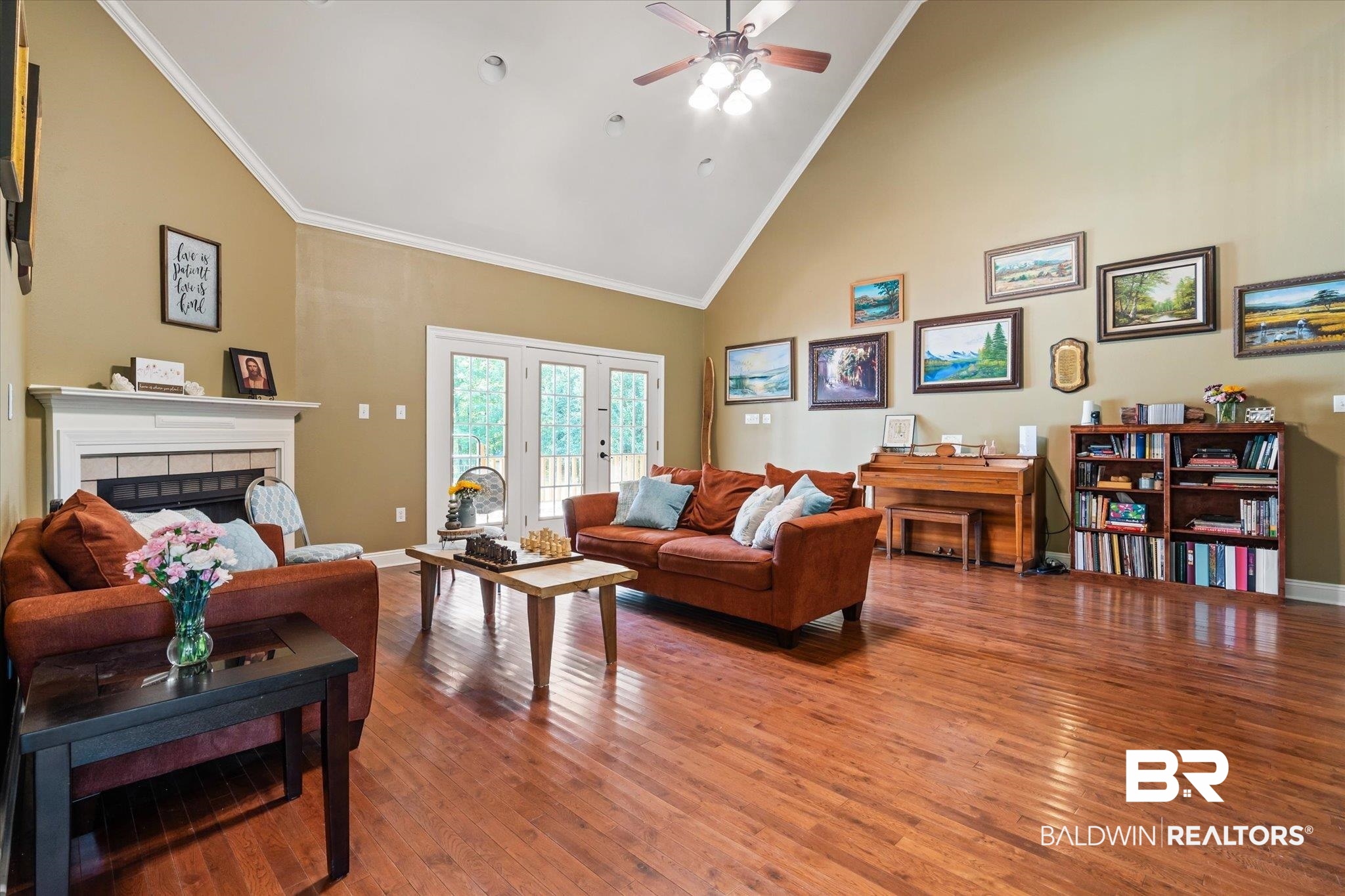 72 Limestone Drive Jackson, AL 36545 - Photo 9 of 38 Living room with a tile fireplace, wood-type flooring, crown molding, high vaulted ceiling, and ceiling fan