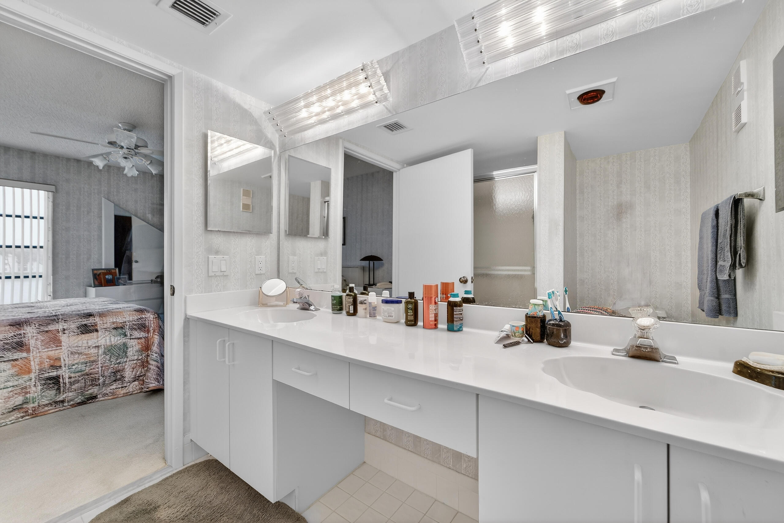 14112 Huntington Pointe Drive, Unit 309 Delray Beach, FL 33484 - Photo 18 of 50 a bathroom with double vanity sinks and a mirror
