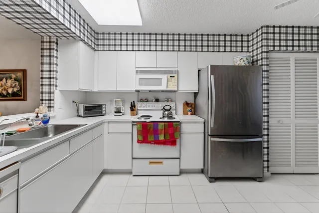 a kitchen with a refrigerator a sink and cabinets