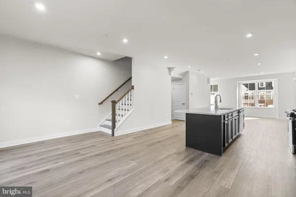 a living room with wooden floor and stairs