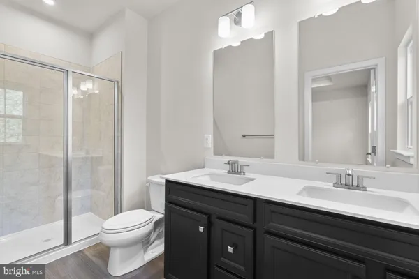 a bathroom with a sink a toilet a mirror and shower