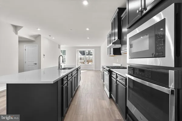a kitchen with stainless steel appliances a sink dishwasher a stove and a refrigerator