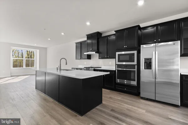 a modern kitchen with granite countertop a refrigerator and a sink