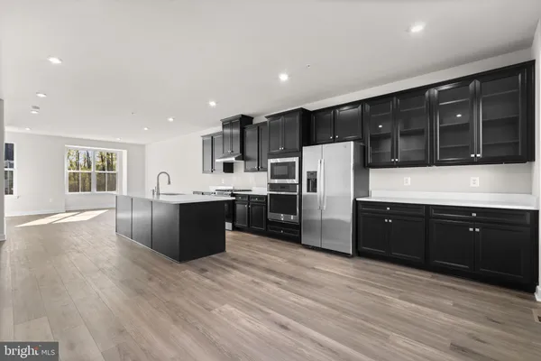 a large kitchen with stainless steel appliances kitchen island granite countertop a stove a sink a refrigerator and cabinets