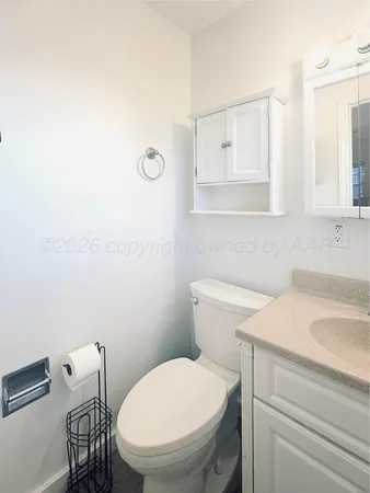 a bathroom with a toilet a sink and mirror