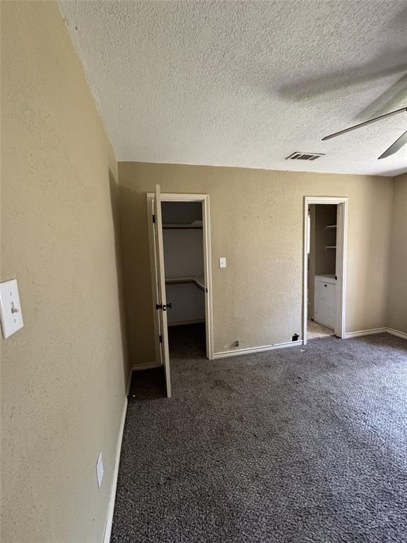 803 Ripley Avenue Ennis, TX 75119 - Photo 22 of 40 Carpeted room featuring two open doorways, textured walls, and a ceiling fan
