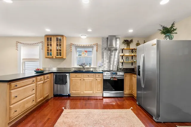 a kitchen with stainless steel appliances granite countertop a stove a sink and a refrigerator