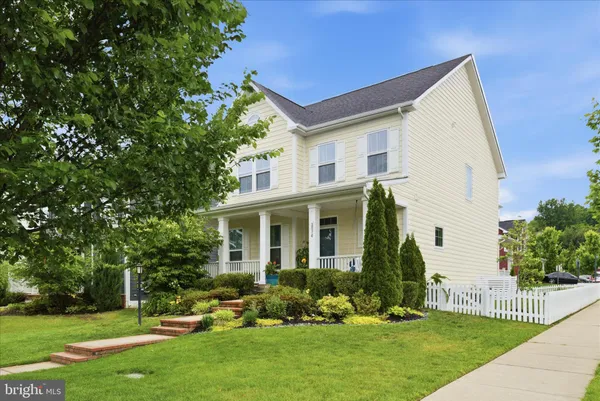 a front view of a house with a yard and green space