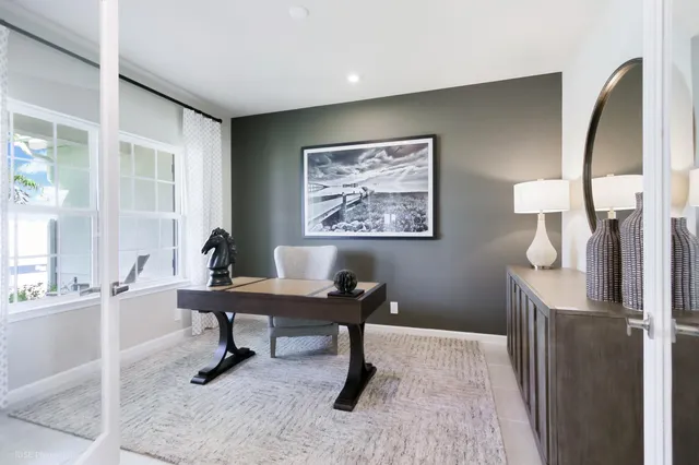 a view of a workspace with furniture and a window