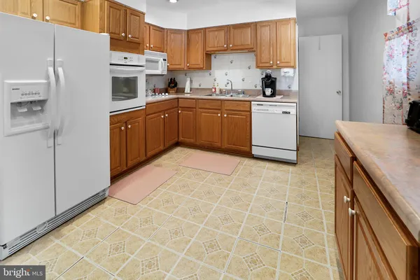 a view of a kitchen with kitchen island granite countertop a sink cabinets and black appliances