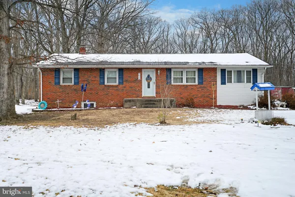 a front view of a house with a yard covered with snow