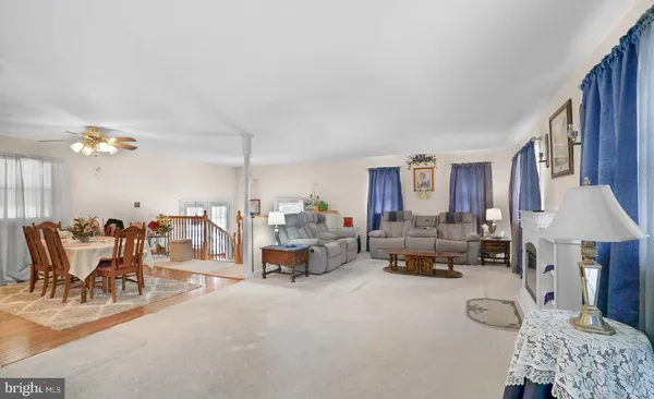 a view of a dining hall with furniture and a kitchen