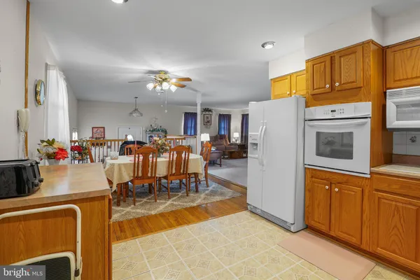 a kitchen with a refrigerator a stove a sink and dishwasher with wooden floor
