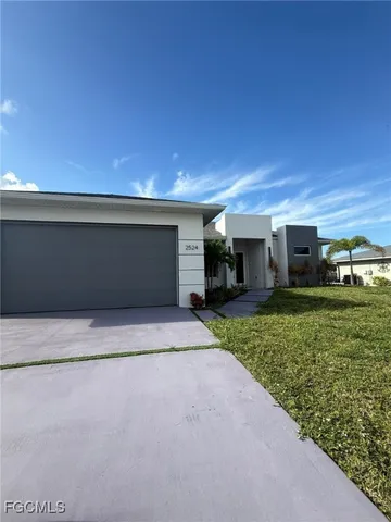 a view of a house with a yard and a garage
