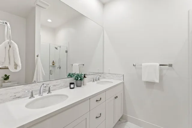 a bathroom with double sink and a mirror
