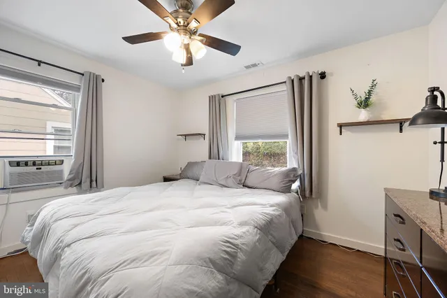 a bedroom with a large bed window and a ceiling fan
