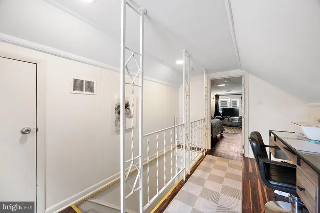 a view of a hallway with wooden floor and furniture