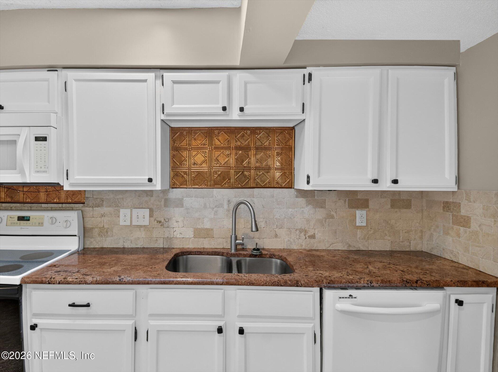 2705 Navajo Road Orange Park, FL 32073 - Photo 25 of 58 a kitchen with granite countertop a sink a stove and cabinets